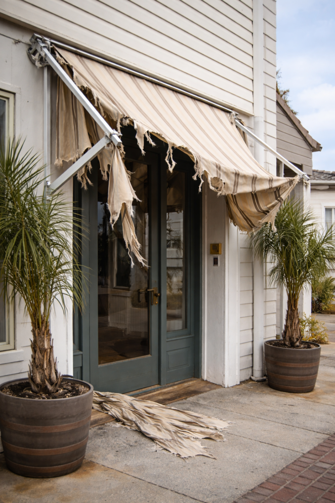 tenda a bracci con struttura rotta e telo strappato dal vento