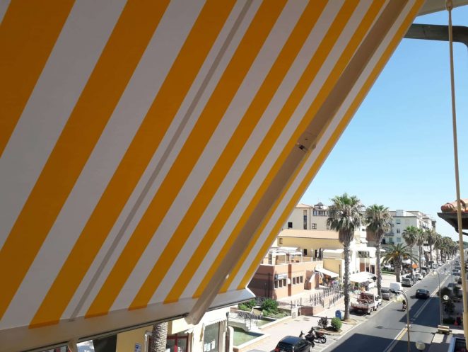 tenda a bracci a righe gialle e bianche per terrazzo a san vincenzo (Livorno)