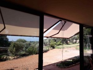 tende a bracci in microforato con struttura color ruggine e con motore e sensore vento