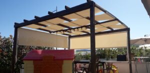 copertura gazebo legno con teli intrecciati e chiusura con tende a caduta verticali