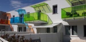 tenda a bracci a tinta unita chiara e motorizzata per giardino in complesso residenziale a livorno